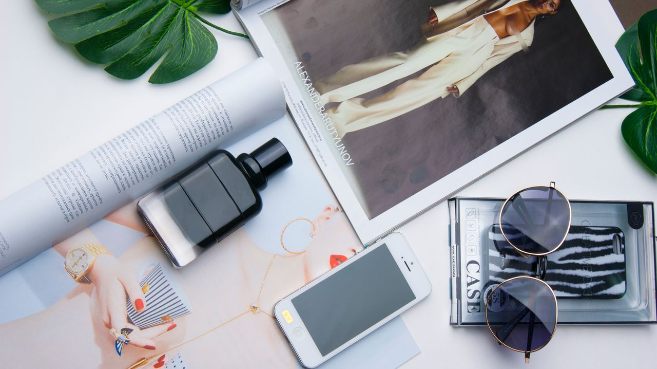 Crafting Captivating Headlines: Your awesome post title goes here Flat lay of fashion items including sunglasses, perfume, and a magazine on a white surface.
